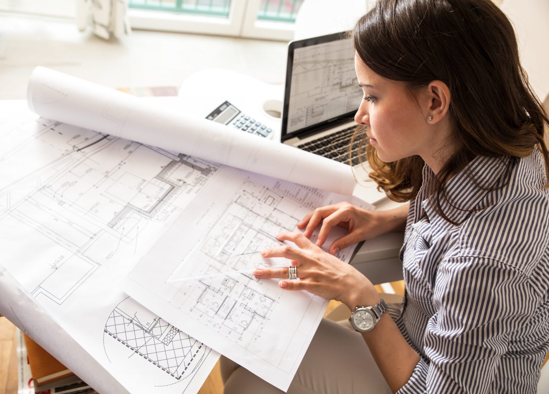 Female architect working at home.She looking at blueprint. Projektentwickler