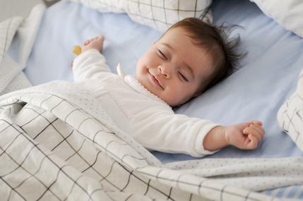 Smiling,Baby,Girl,Lying,On,A,Bed,Sleeping,On,Blue smart home